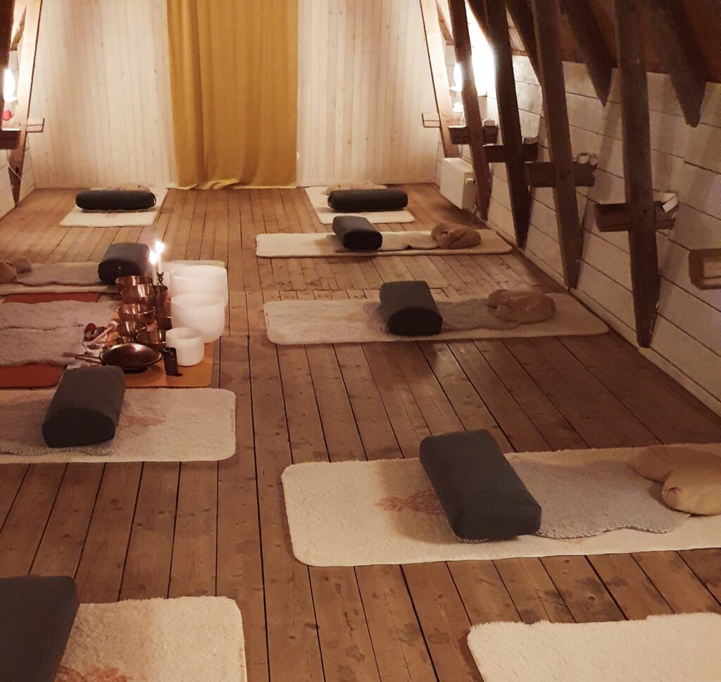 Lokal med tröägolv, på trägolvet ligger vita yogamattor
